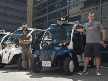 Photo of electric vehicle and two reserchers